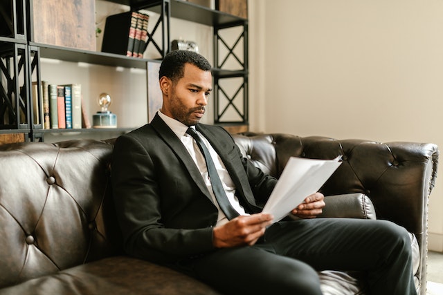 a tenant in a black suit and tie reviews the cleaning clause in their lease agreement