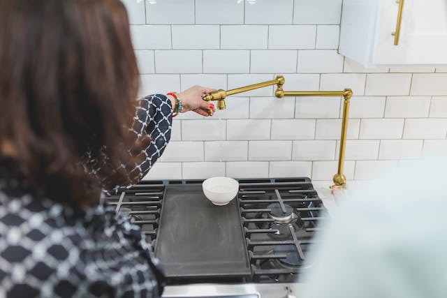 kitchen tap in front of backsplash