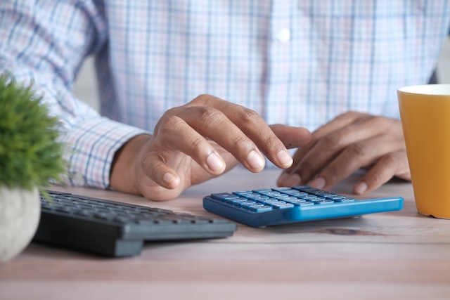 person entering numbers on a blue calculator