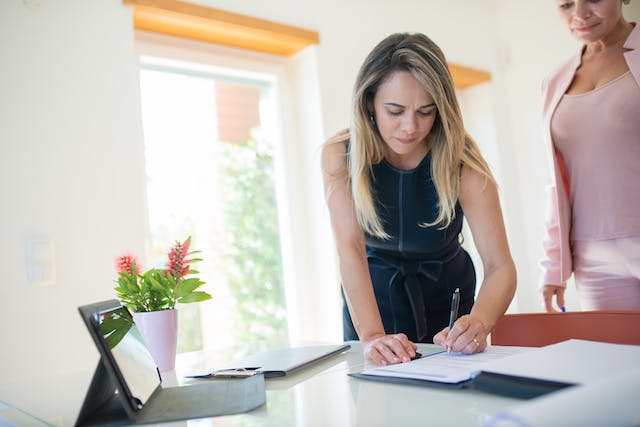 person in black signing a document
