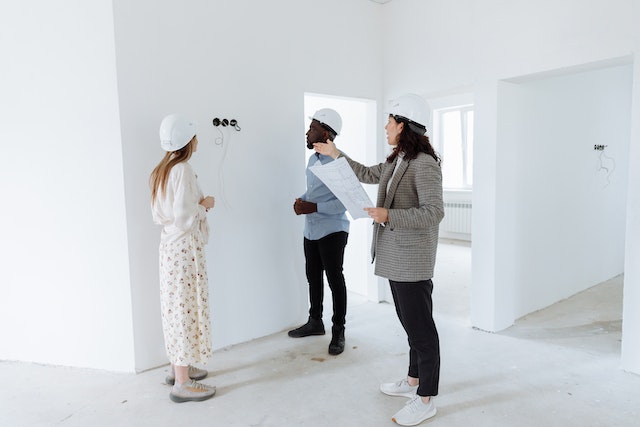 a home inspector assesses electrical wiring with potential investment home buyers