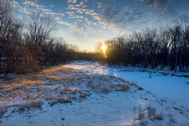 the sun sets over a natural landscape on the edge of saskatoon